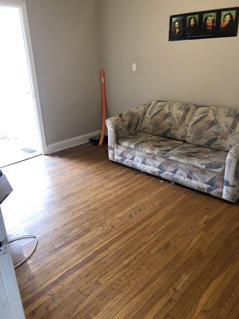 a living room with a couch and a wooden floor