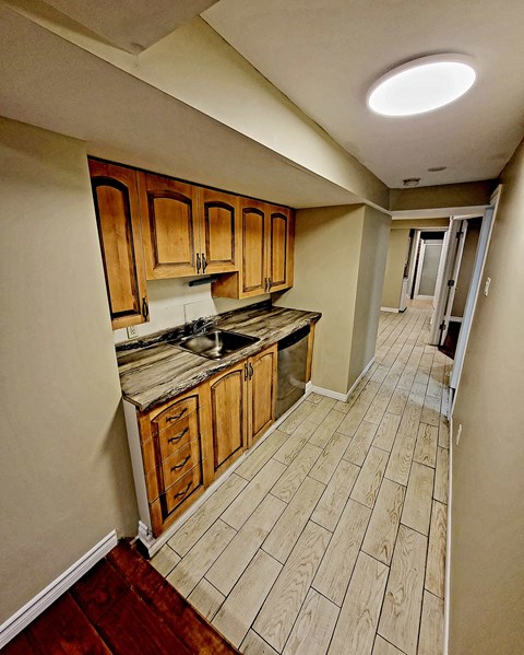 a kitchen with wooden cabinets and a wooden floor