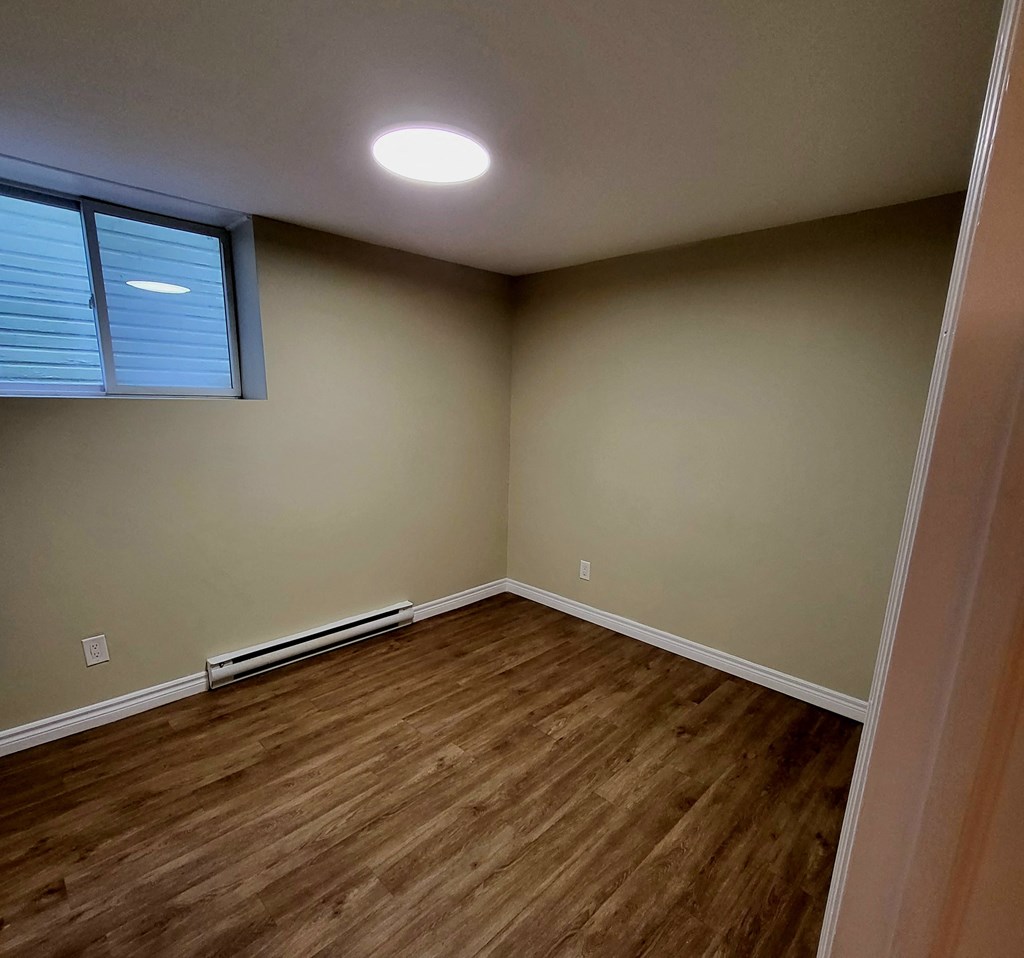 a empty room with wooden floors and a window