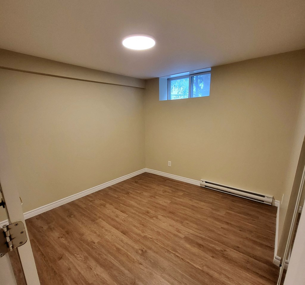 a empty room with wooden floors and a window