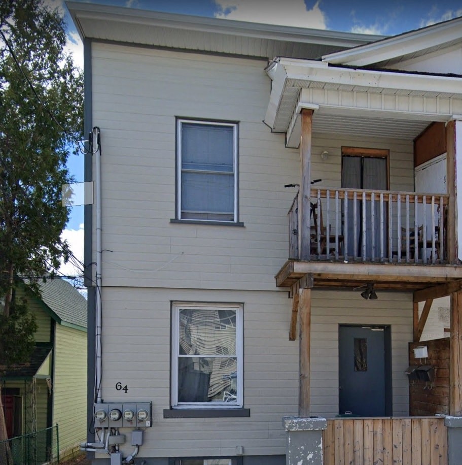 a white house with a balcony and a blue door