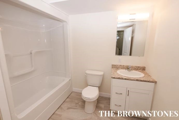 a bathroom with a toilet and a sink and a shower