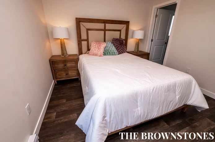 a bedroom with a white bed and two lamps