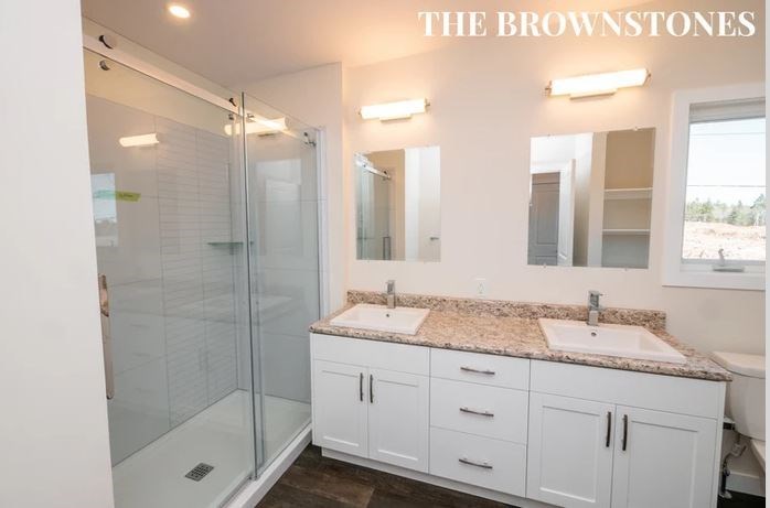 a bathroom with two sinks and a glass shower