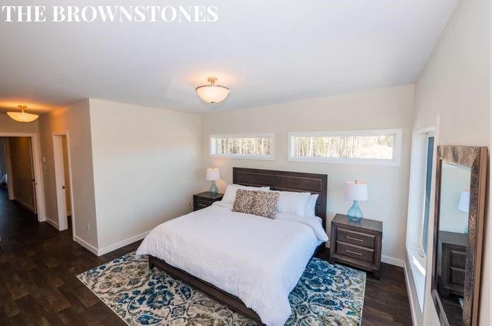 a bedroom with a white bed and a wooden floor