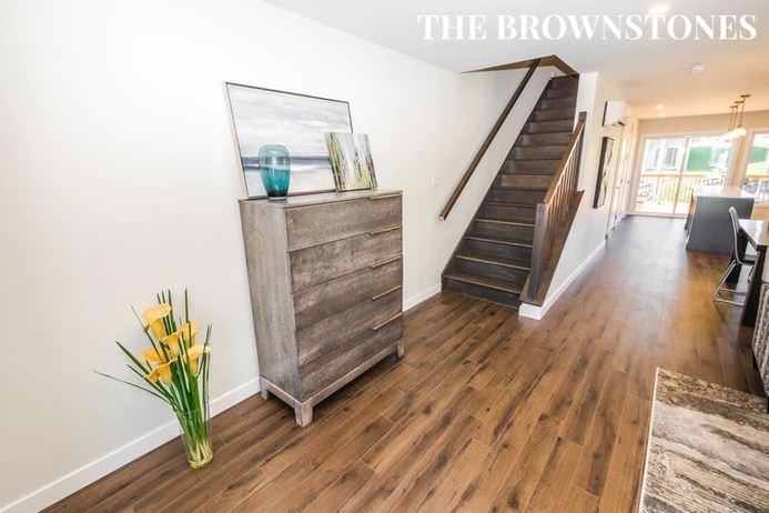 a living room with wood floors and a staircase