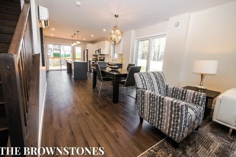 a living room and dining room with a table and chairs