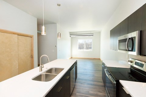 an empty kitchen with a sink and a counter top