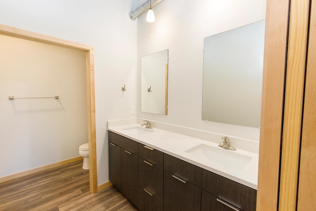 a bathroom with two sinks and a mirror and a toilet