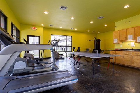 a gym with a treadmill and a table