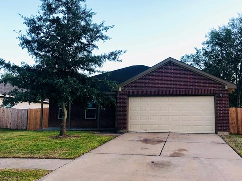 a house with a garage and a tree in front of it