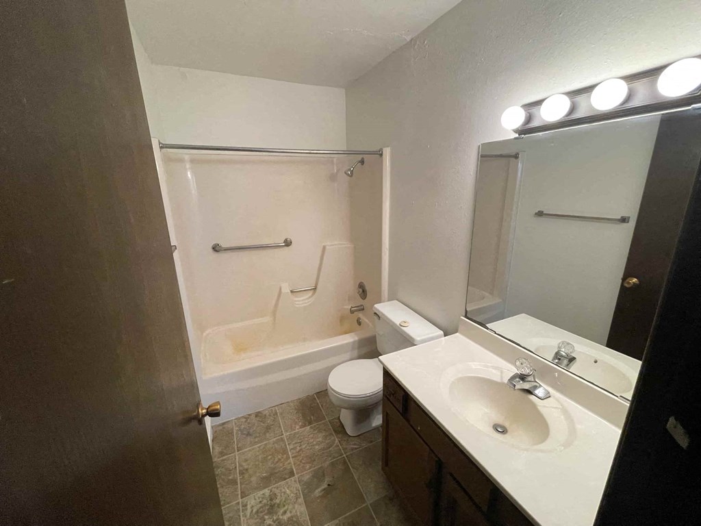A bathroom with a toilet, sink, and bathtub.