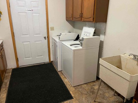 A white door with a sign that says "No Trespassing" is in a room with a washer and dryer.