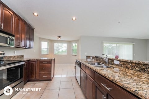 a large kitchen with granite counter tops and wooden cabinets