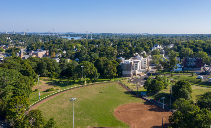 an aerial view of a park with a city in the background
