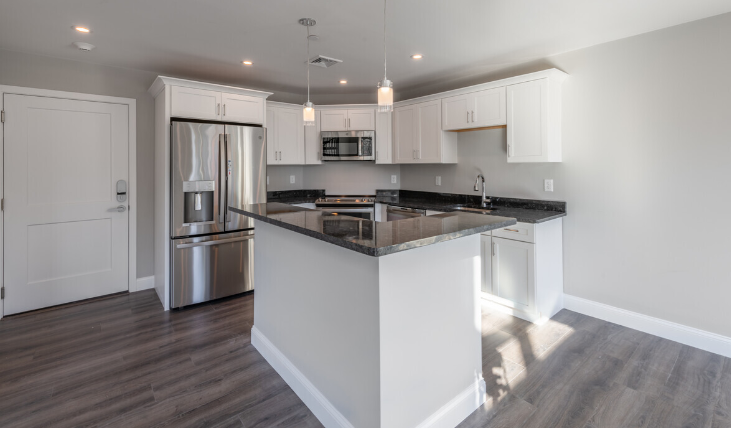a kitchen with an island and a stainless steel refrigerator