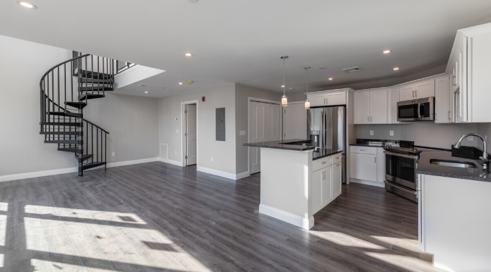 a kitchen with white cabinets and a spiral staircase