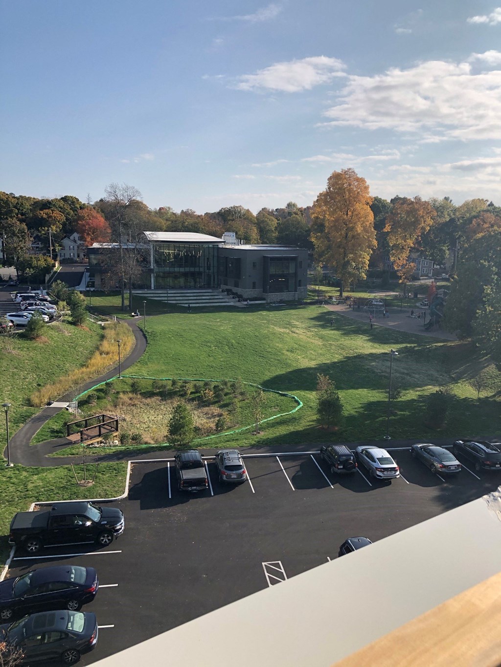 a view of a parking lot and a building from a balcony