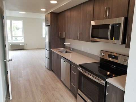 an empty kitchen with wooden cabinets and stainless steel appliances