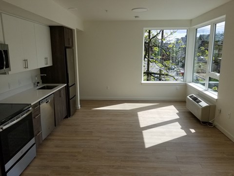 an empty kitchen with a large window in the middle of it