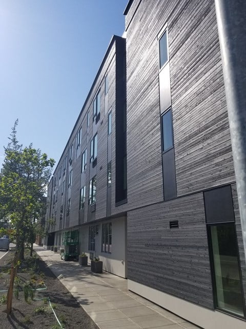 the side of a building with a sidewalk in front of it