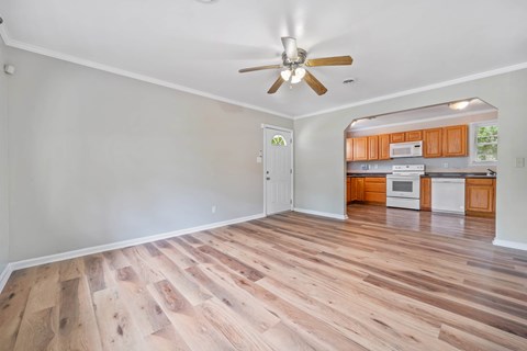 A room with wooden flooring and a ceiling fan.