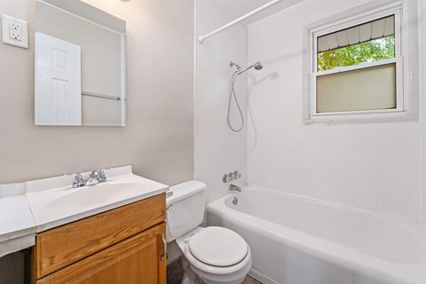 A white bathroom with a toilet, sink, and bathtub.