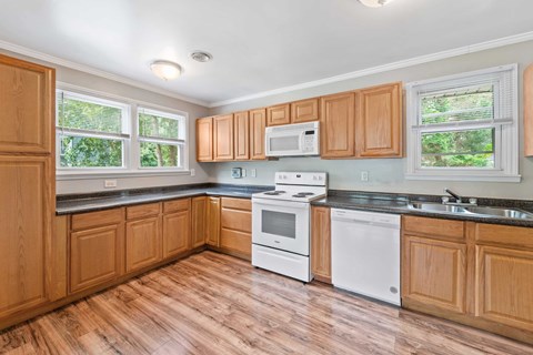 A kitchen with wooden cabinets and white appliances.