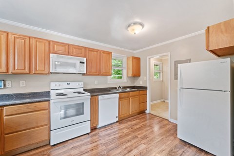 A kitchen with wooden cabinets and white appliances.