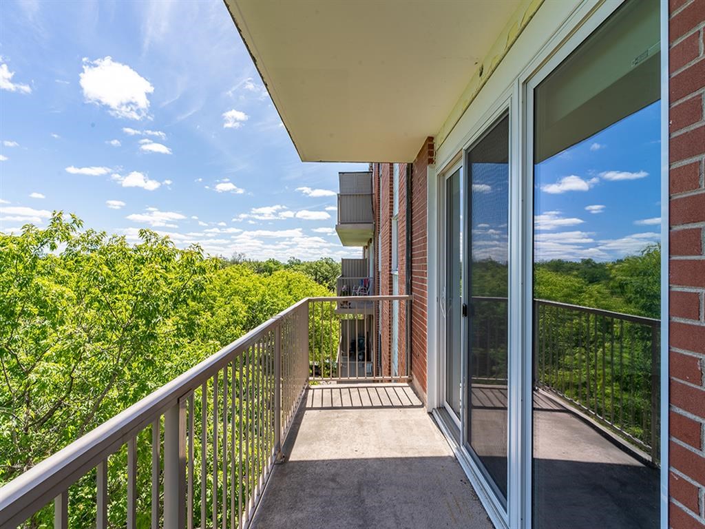 a balcony with a view of trees and a blue sky