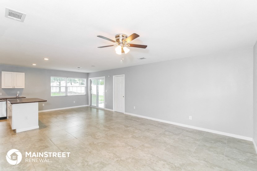 the living room and kitchen are spacious with tile flooring and a ceiling fan