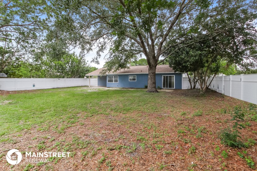 a blue house with a yard and a tree