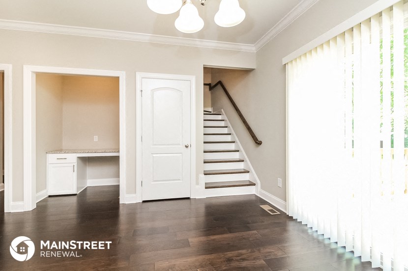 an empty room with a staircase and a white door