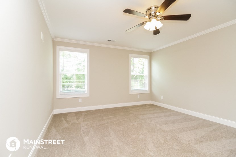 the master bedroom is spacious and clean with a ceiling fan