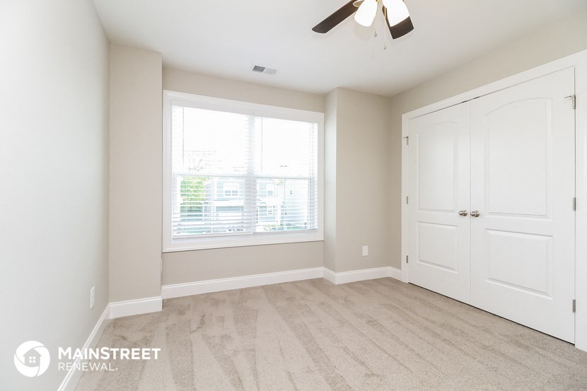 a bedroom with a large window and a closet