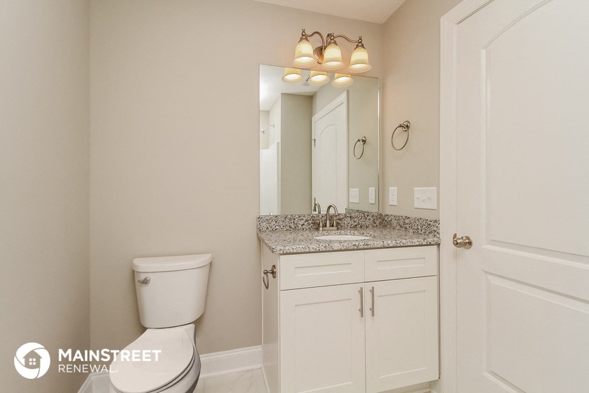 a bathroom with a toilet and a sink and a mirror