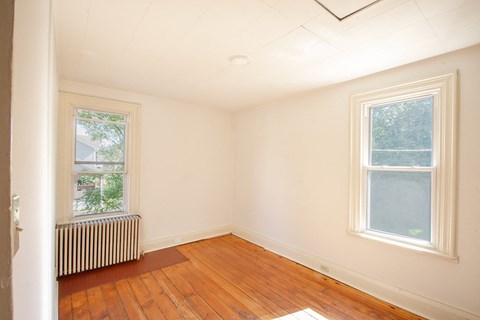 A room with a window and a radiator on the floor.