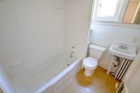 A white toilet sits next to a sink in a small bathroom.