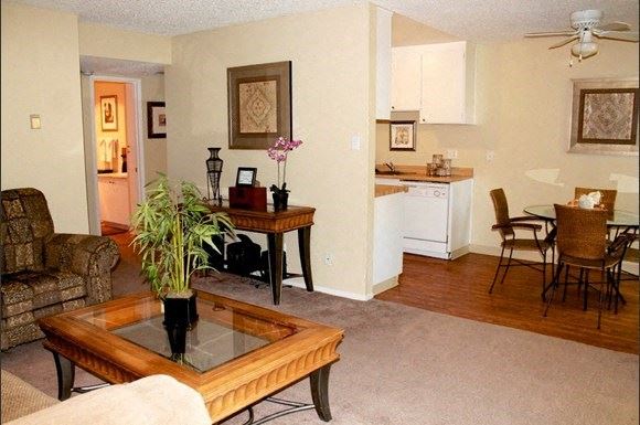 a living room with a coffee table and a kitchen