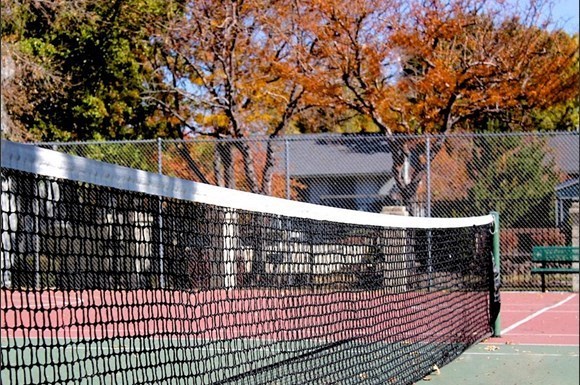 a tennis net on a tennis court in front of a house