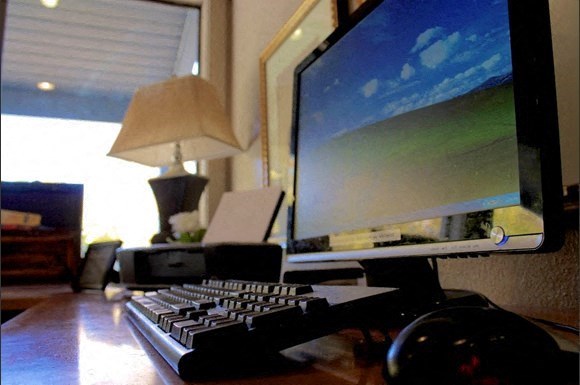 a computer desk with a keyboard and a monitor