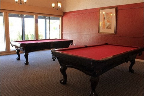 two pool tables in a room with red pool tables