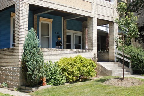 A house with a blue door and a window with a number 435 on it.