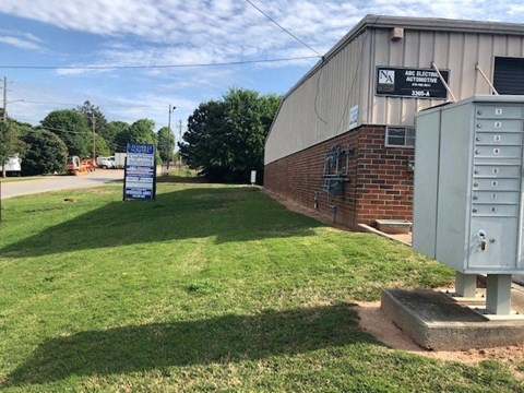 a building with a mailbox and a sign in the grass