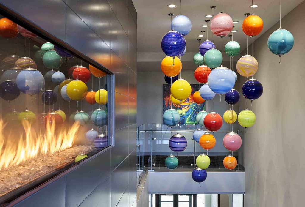 colorful spheres hanging from the ceiling in front of a fireplace