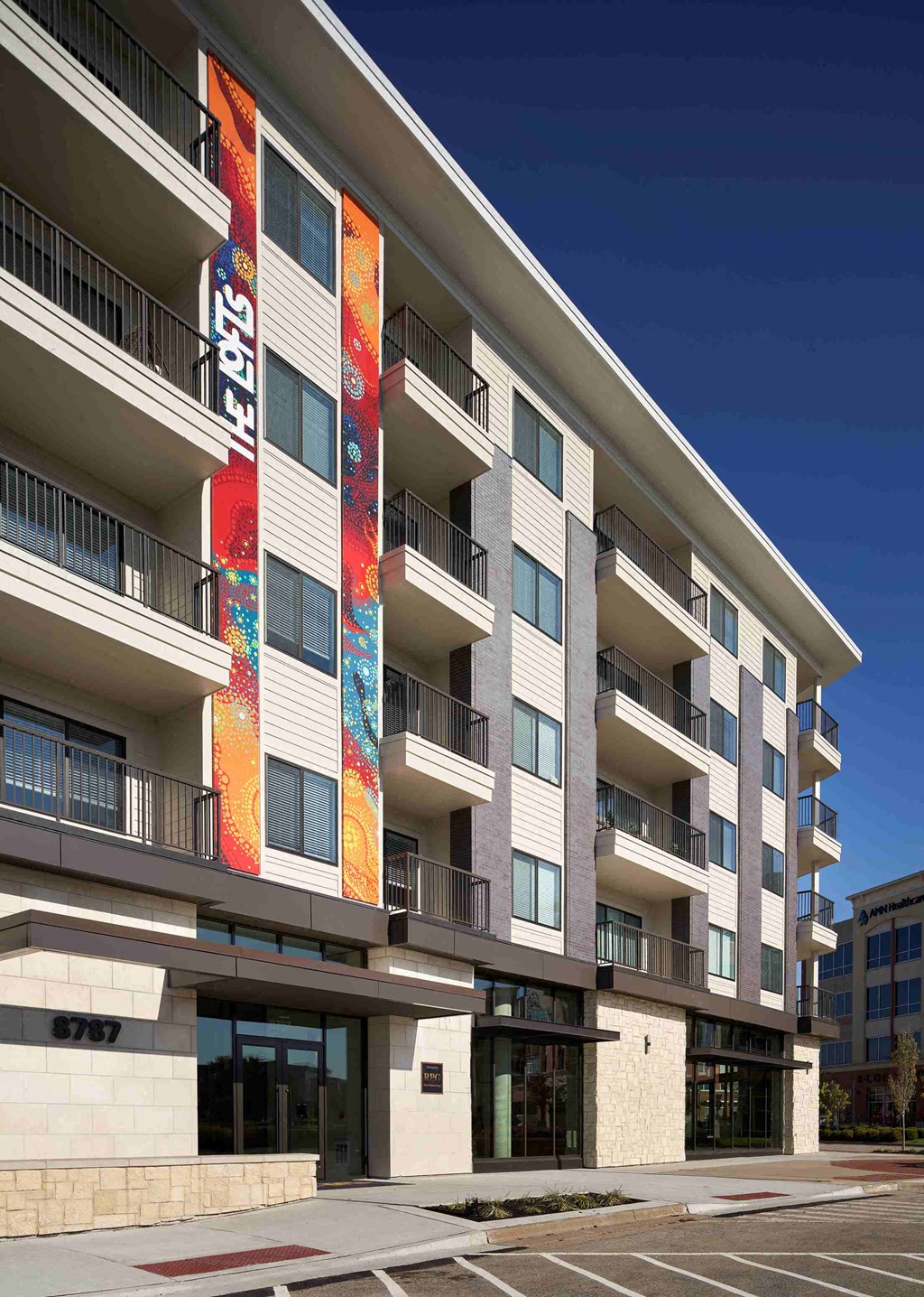 an exterior view of an apartment building with a parking lot