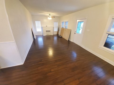 Empty room with wooden floors and white walls.