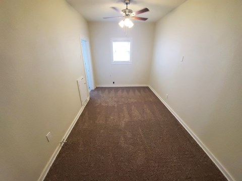 A room with a ceiling fan and a window.