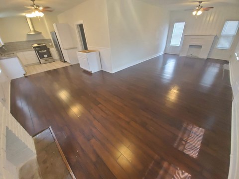 A large open room with wood flooring and a fireplace.