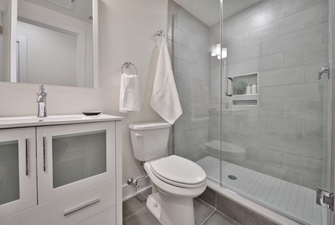 a white bathroom with a shower and a toilet